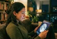 Persona observando la Luna en una pantalla digital, reflejando cómo vemos eventos en internet hoy