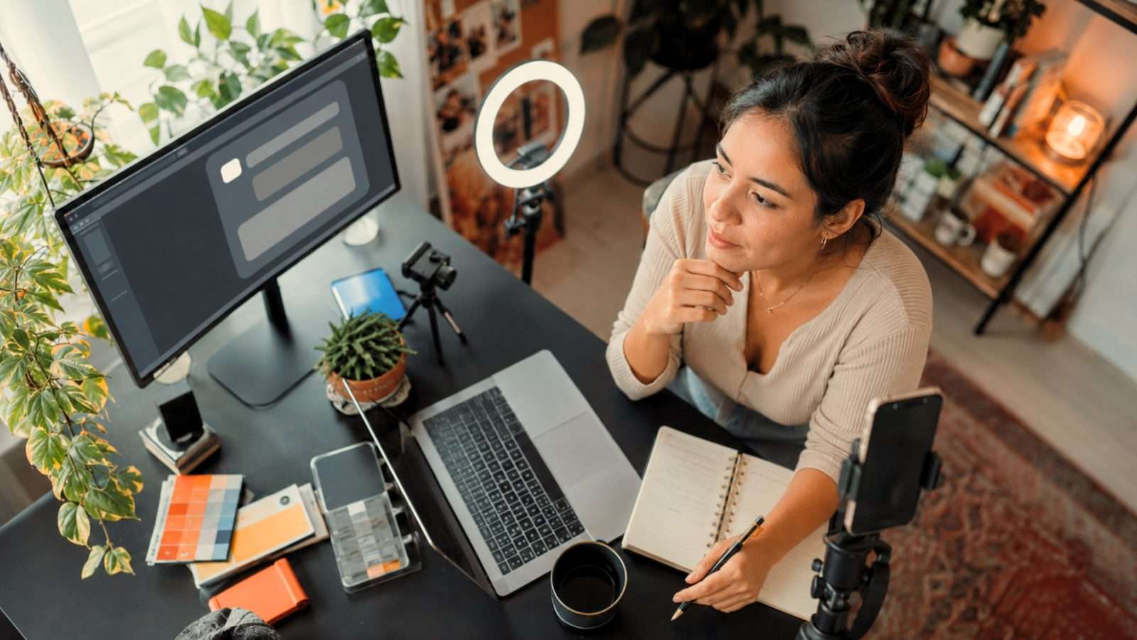 Mujer preparando su imagen digital frente a una computadora y herramientas de creación en una escena sobre presencia en internet e inteligencia artificial.