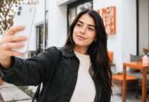 Joven tomándose una selfie en un espacio público tranquilo.